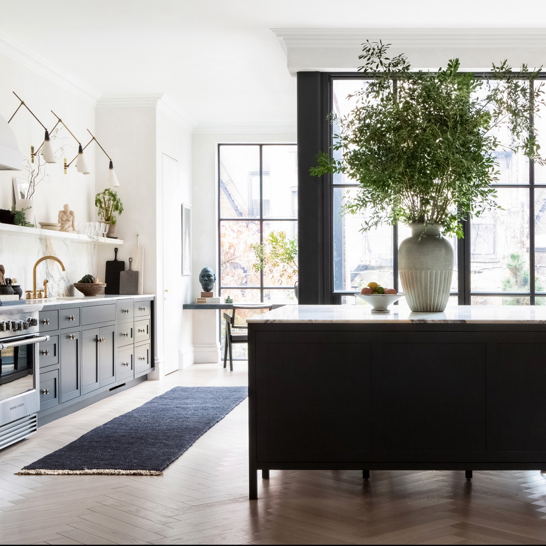 a kitchen with a large potted plant on the island