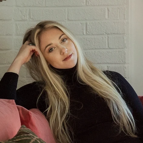 a woman sitting on a red couch with a book