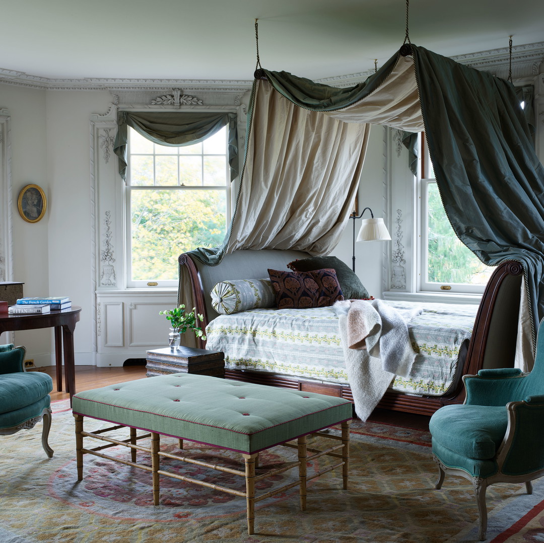 a bedroom with a canopy bed and chairs