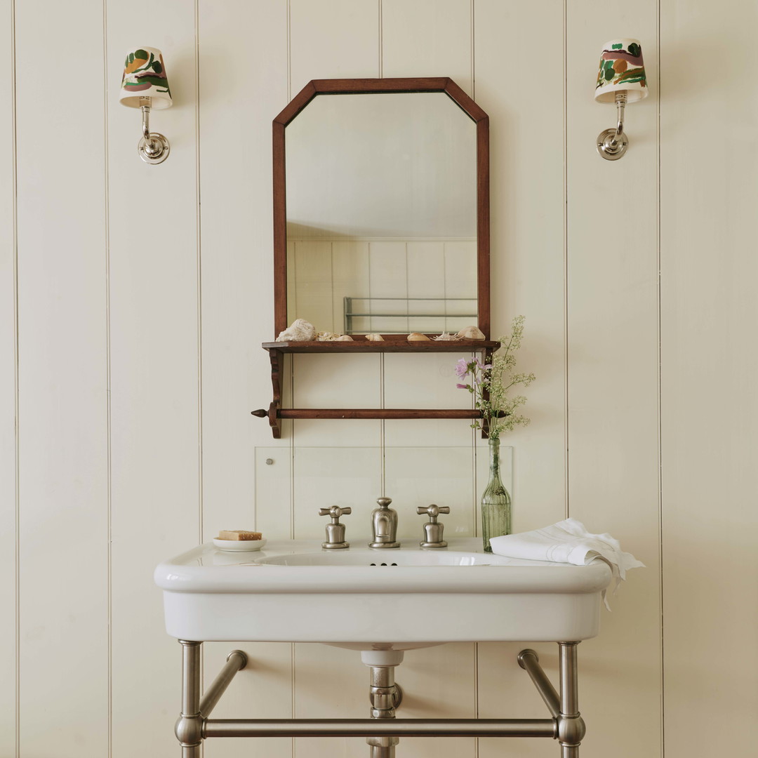 a white sink sitting under a mirror in a bathroom