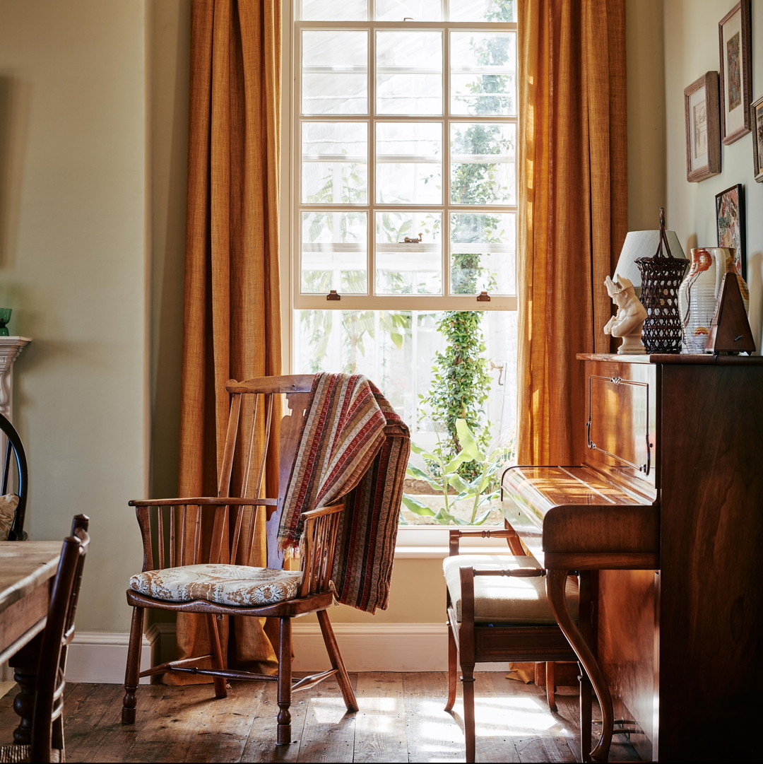 a living room with a piano and a chair