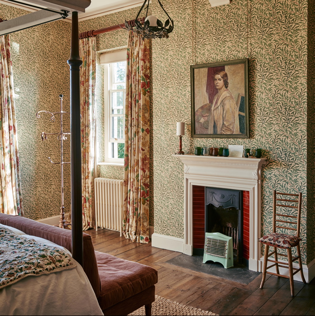 a bedroom with a fireplace and a painting on the wall