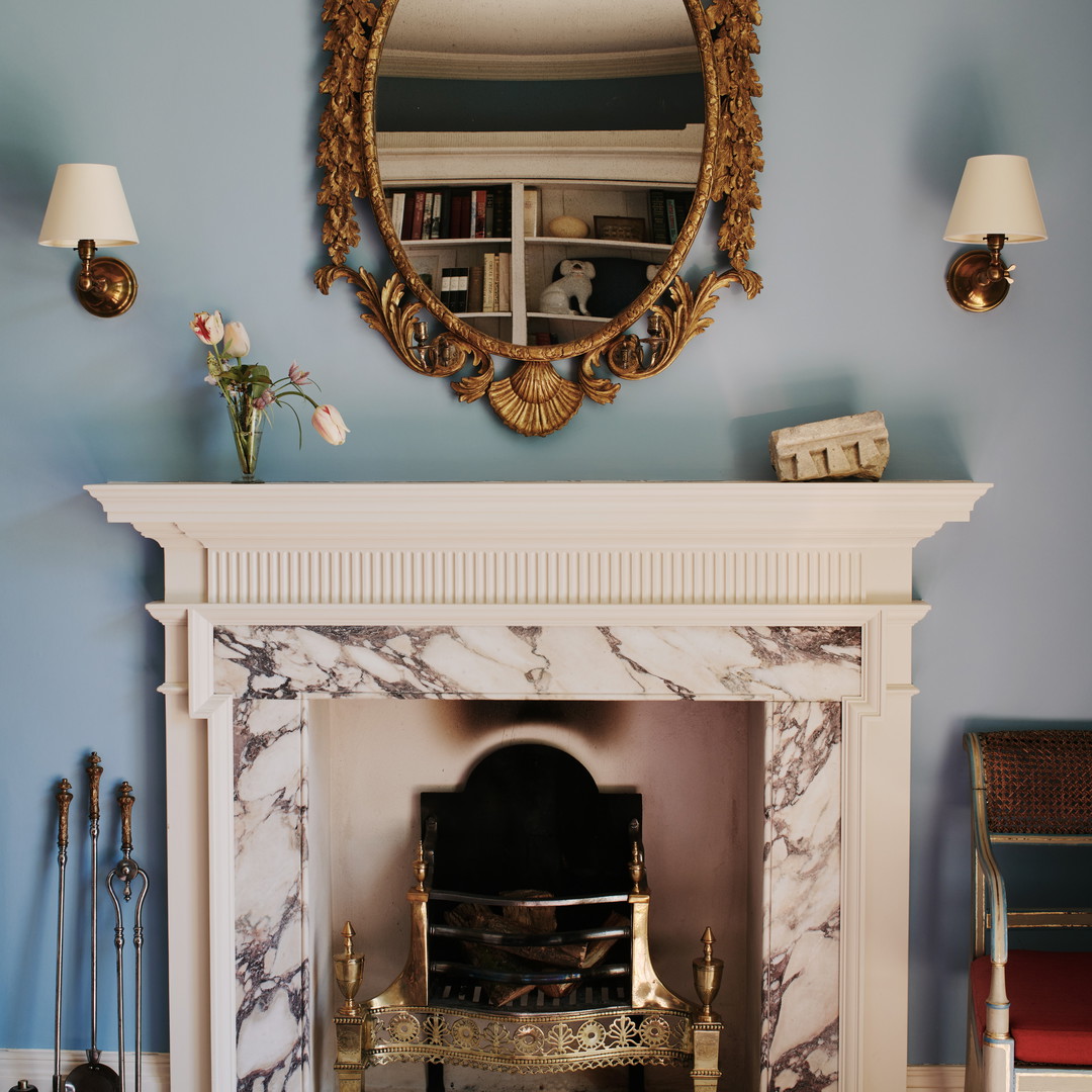 a living room with a fireplace and a mirror above it