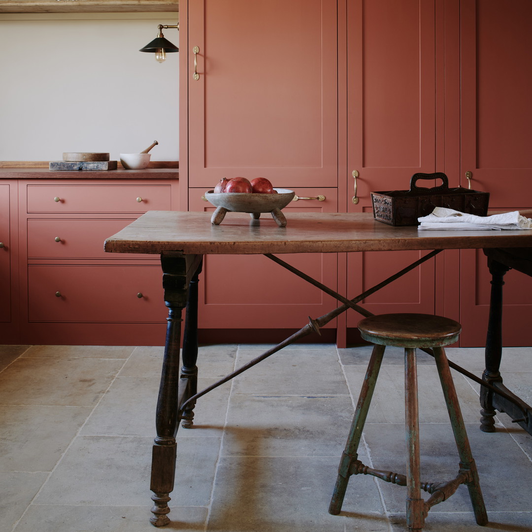 a kitchen with pink cabinets and a wooden table