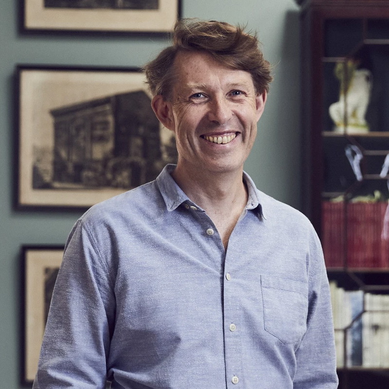 a man standing in front of a book shelf