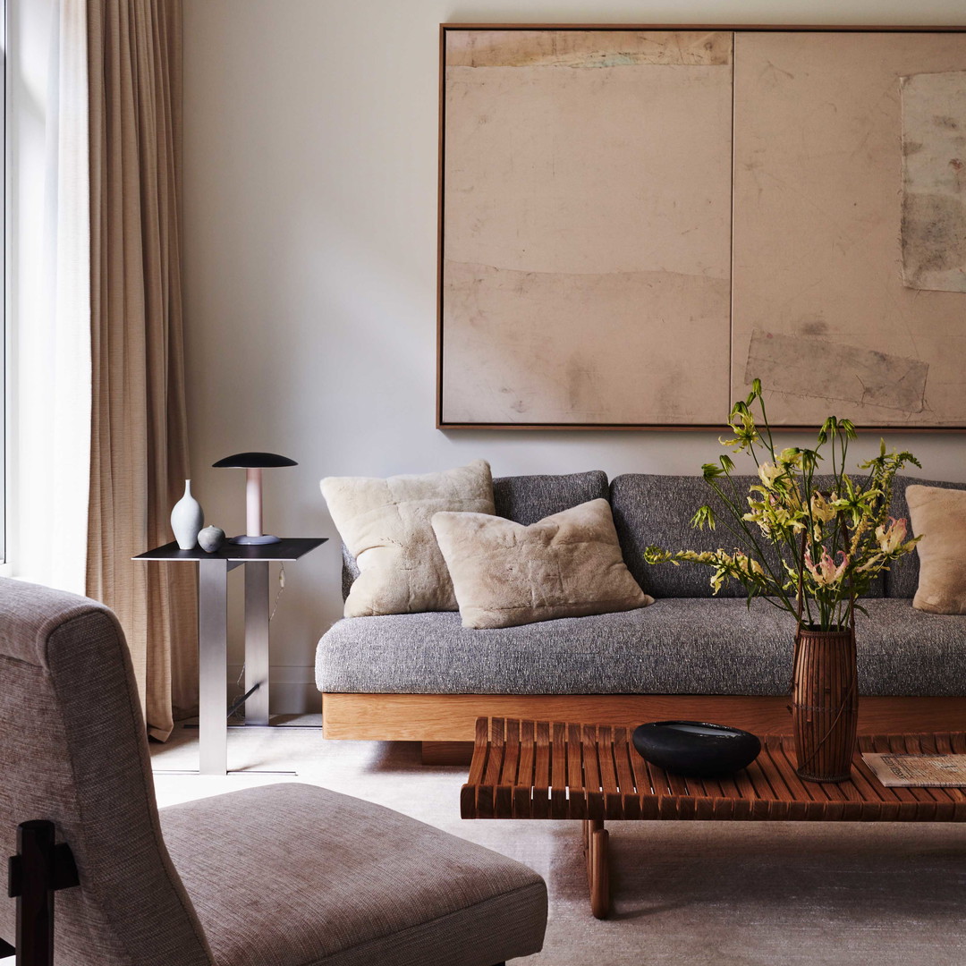 a living room filled with furniture and a painting on the wall