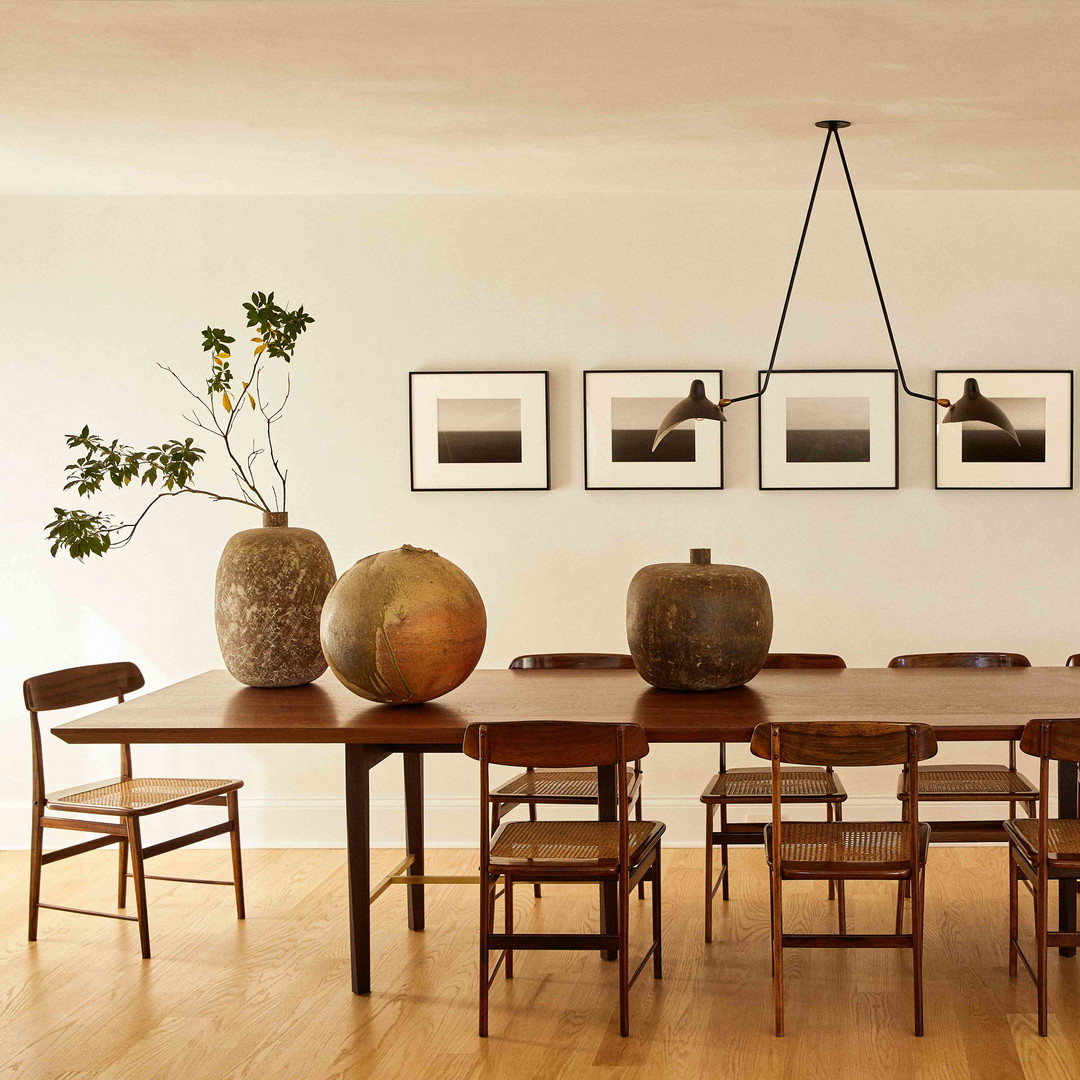 a dining room table with chairs and vases on it