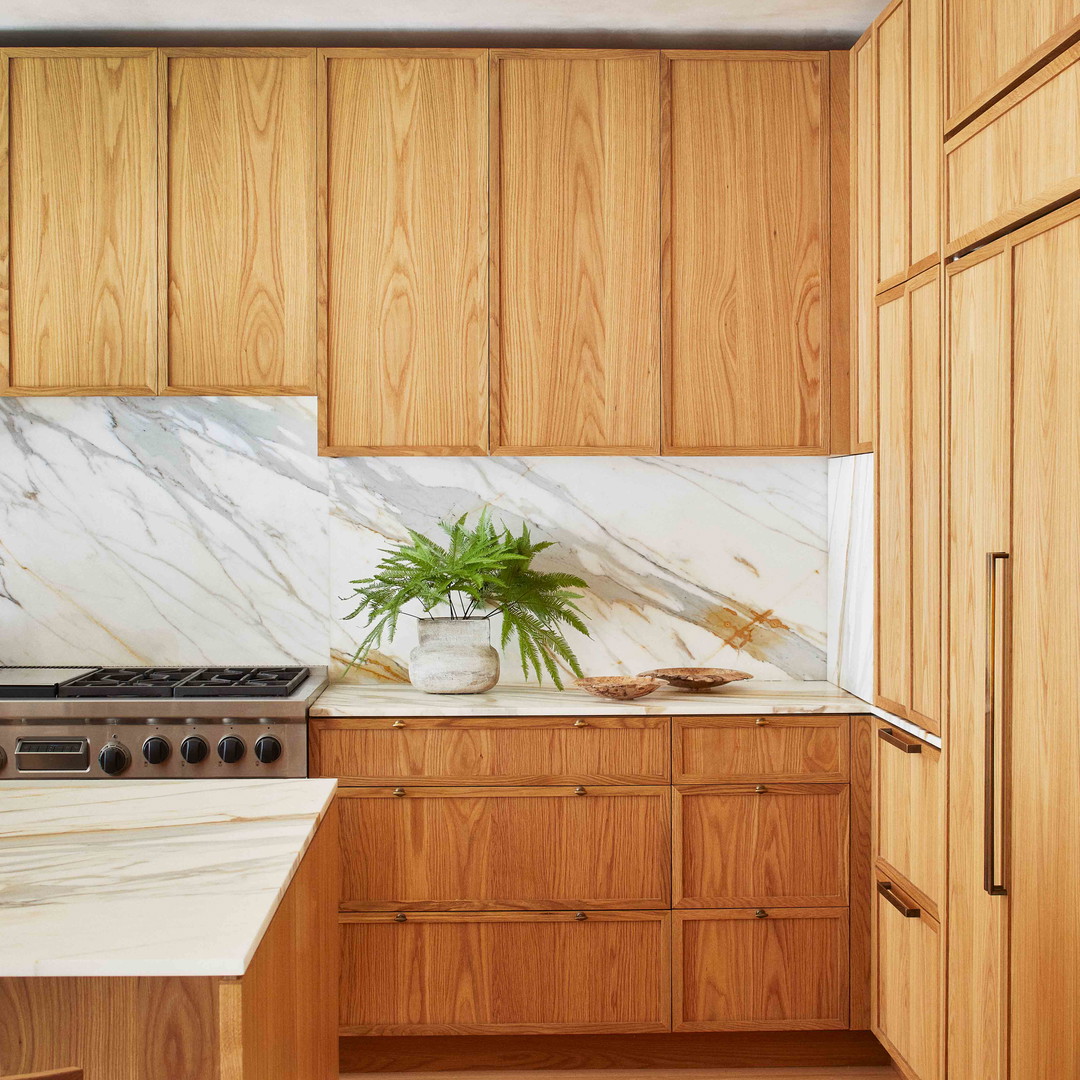 a kitchen with wooden cabinets and a marble counter top