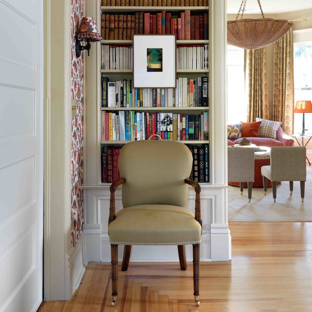 a chair in a room with a bookcase full of books