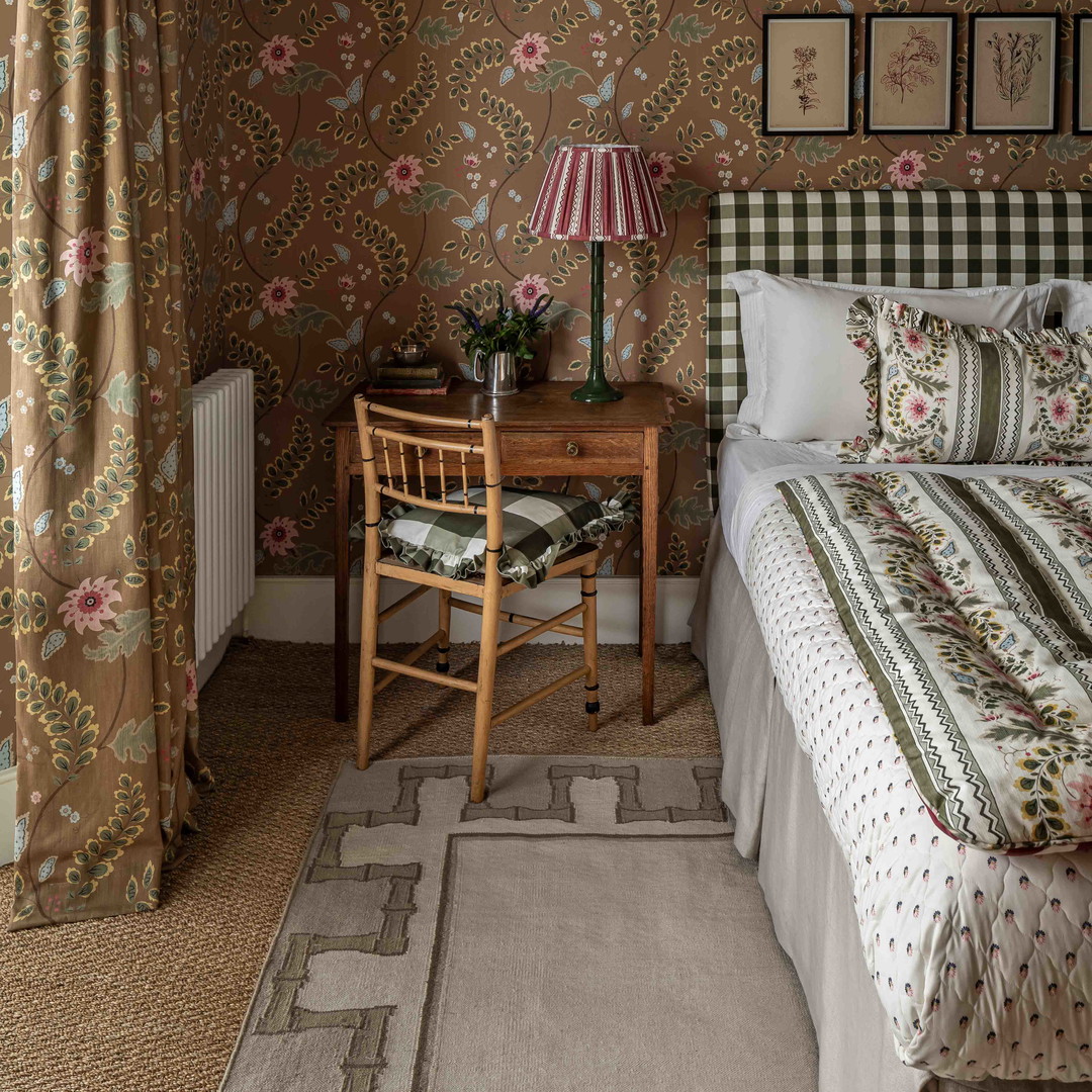 a bedroom with floral wallpaper and a bed