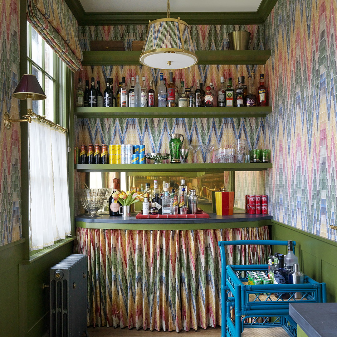 a kitchen with green walls and colorful wallpaper