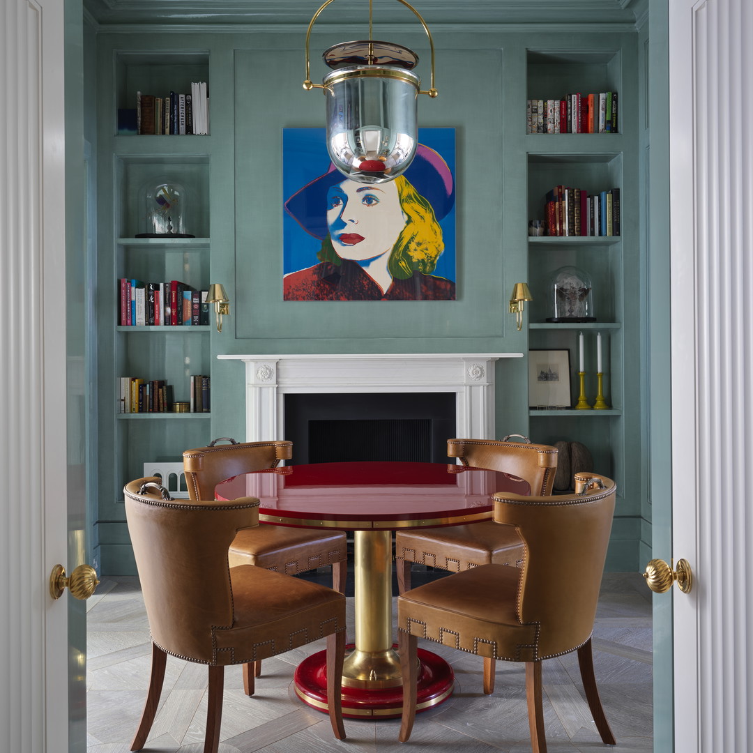 a dining room with a painting on the wall