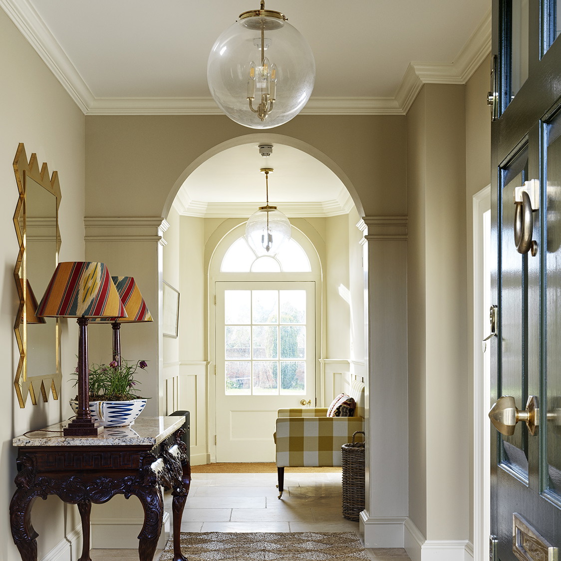 a hallway with a table and a lamp