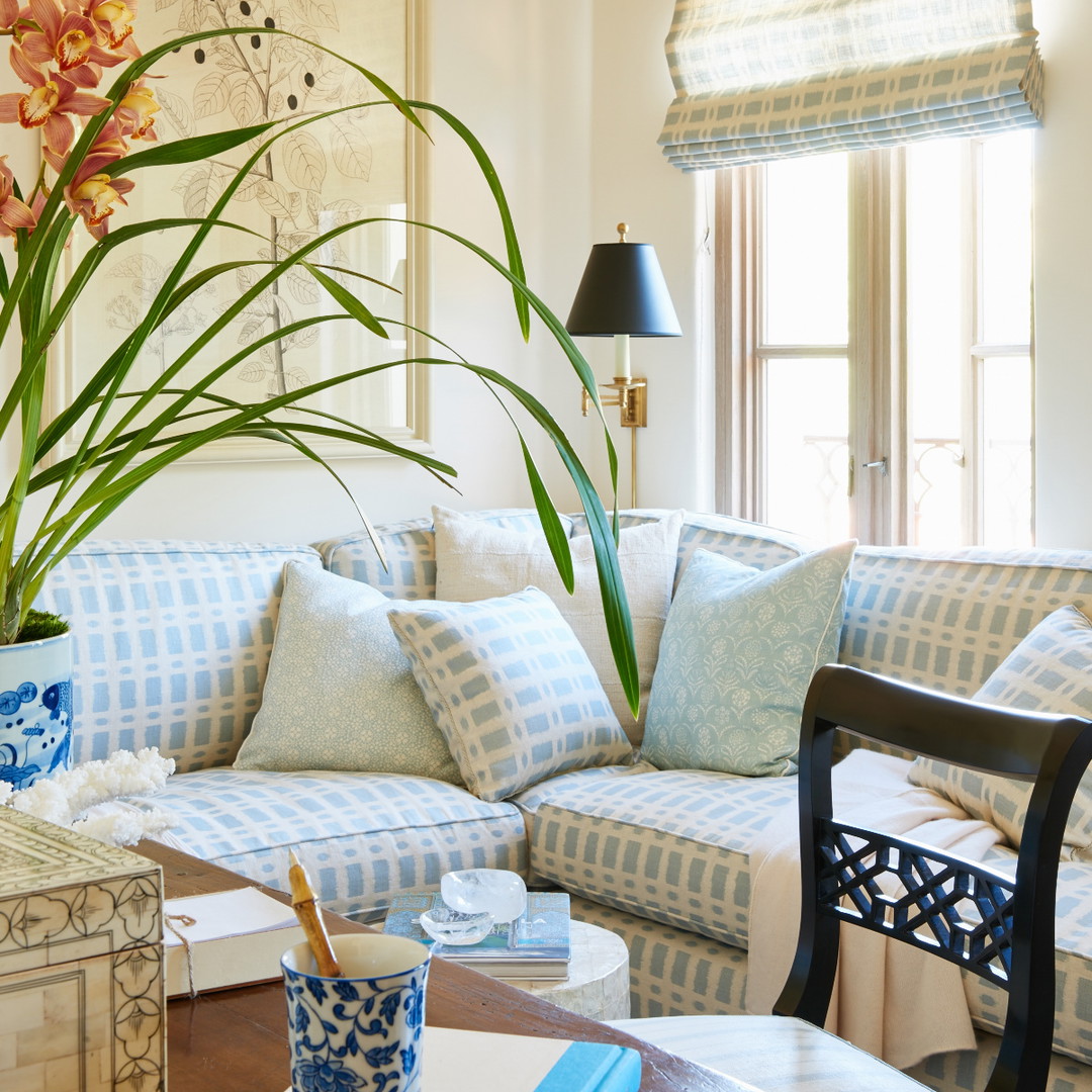 a living room filled with furniture and a vase filled with flowers