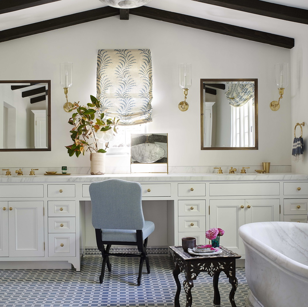 a white bathroom with a blue chair and a white tub