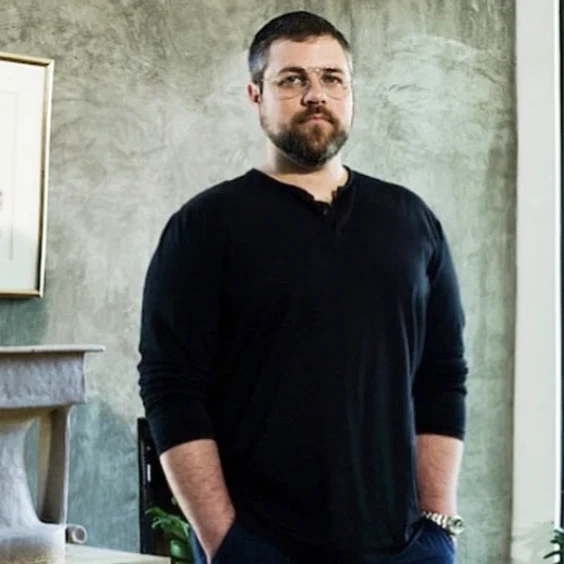 a man standing in a living room next to a table