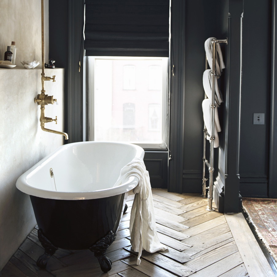 a bathroom with a claw foot tub and black walls