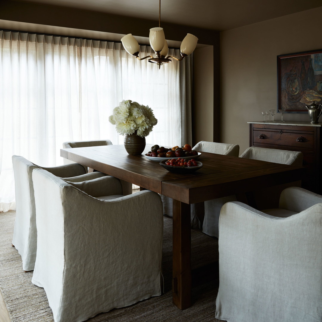 a dining room table with a bowl of fruit on it