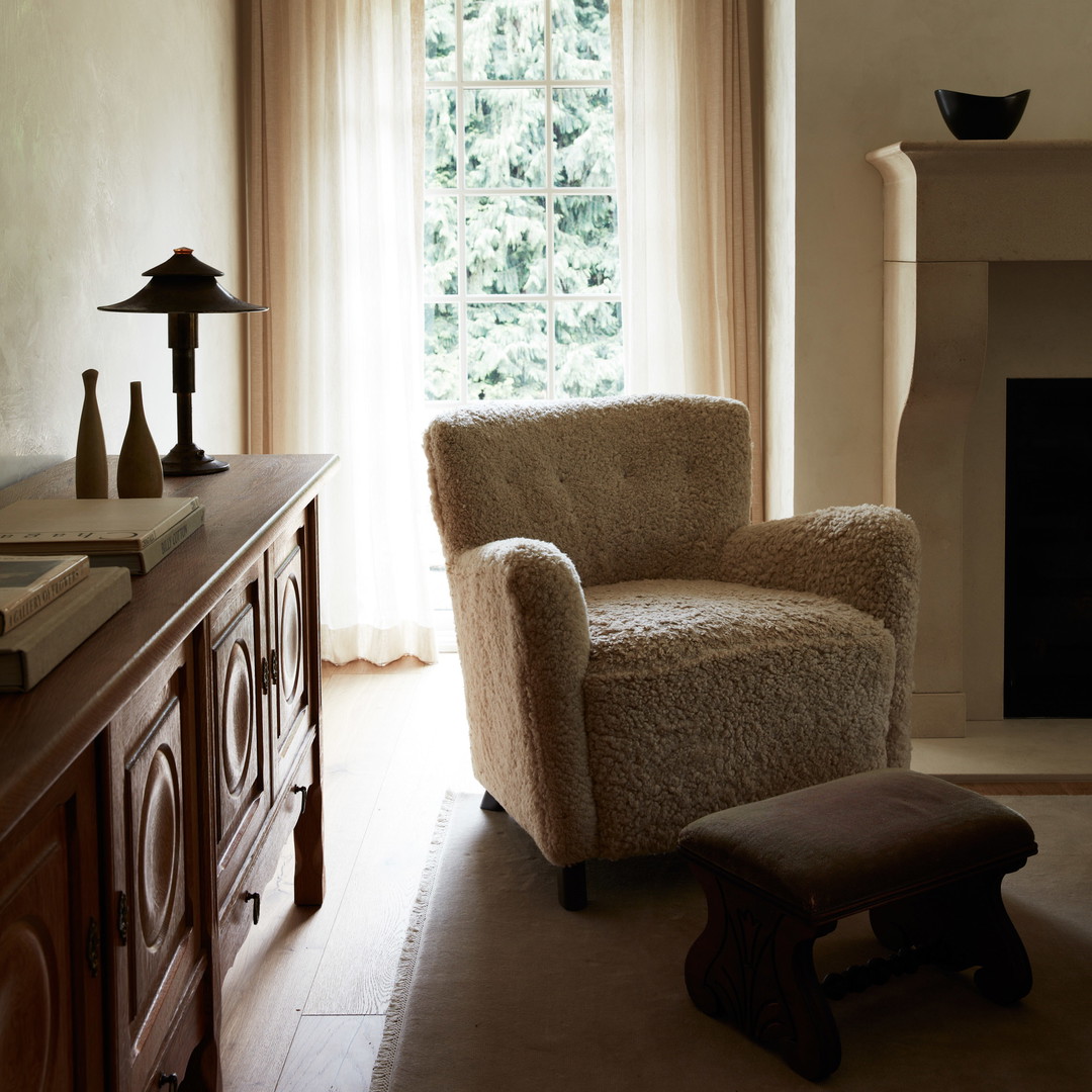 a living room with a chair and a fireplace