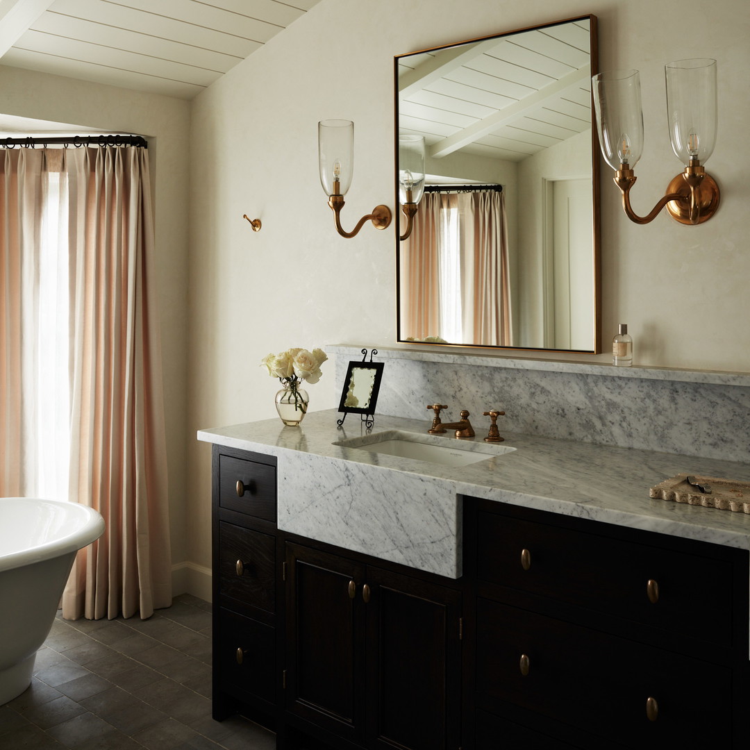 a bath room with a bath tub a sink and a mirror