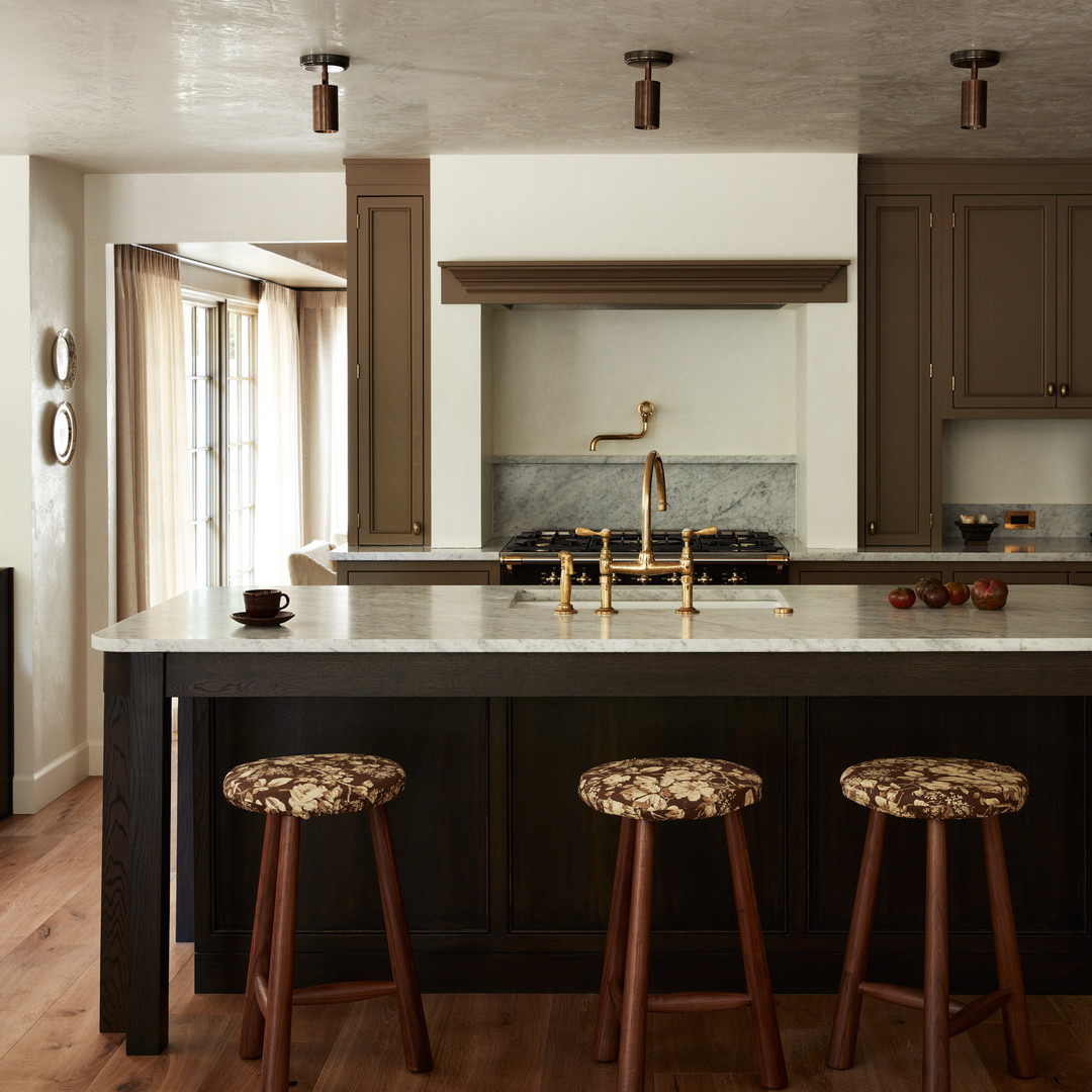 a kitchen with two stools and a center island