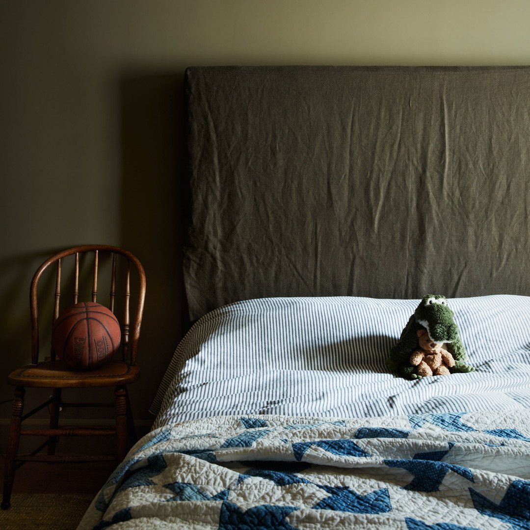 a teddy bear laying on a bed in a bedroom