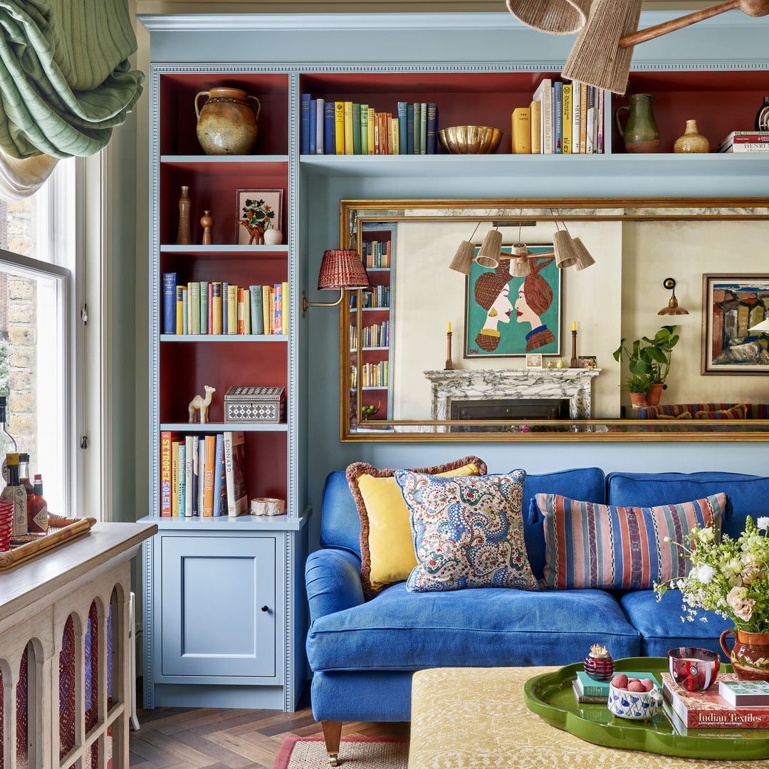 a living room with a blue couch and bookshelf