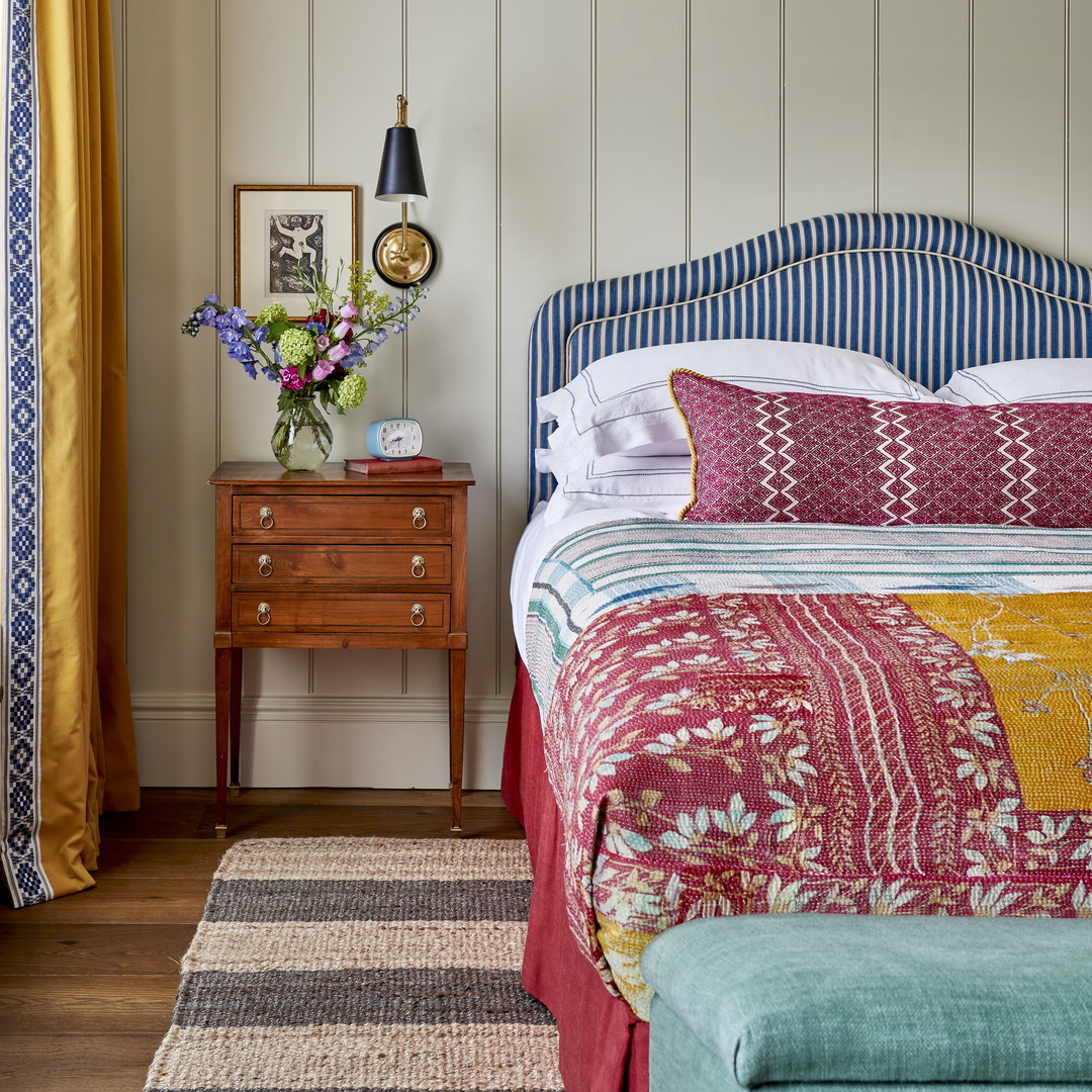 a bedroom with a bed, dresser, and window