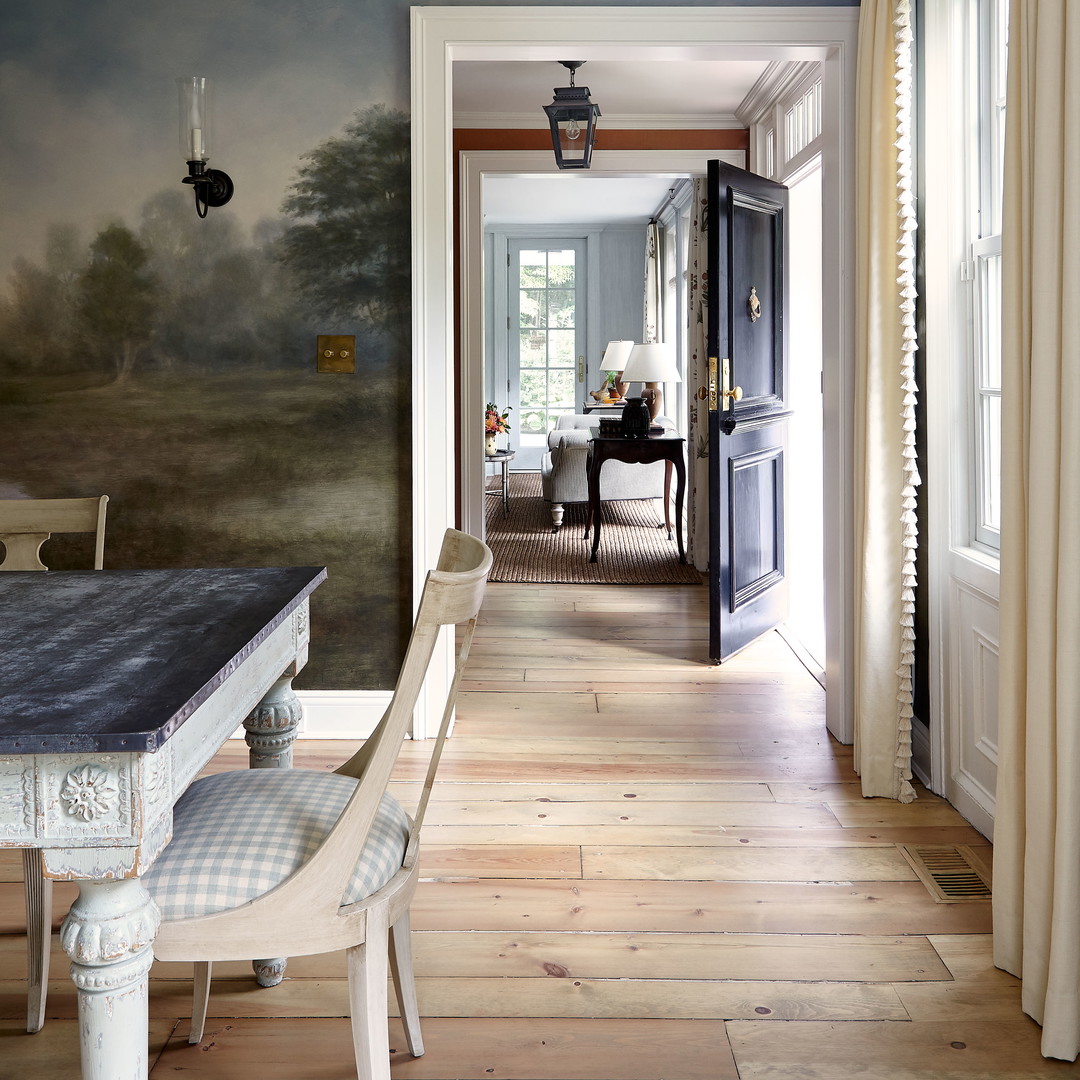 a dining room with a painting on the wall