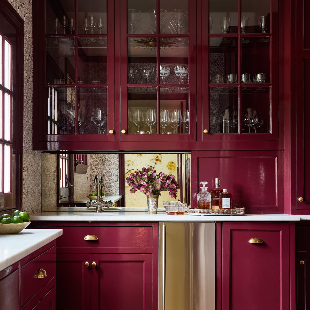 a kitchen with red cabinets and a silver dishwasher