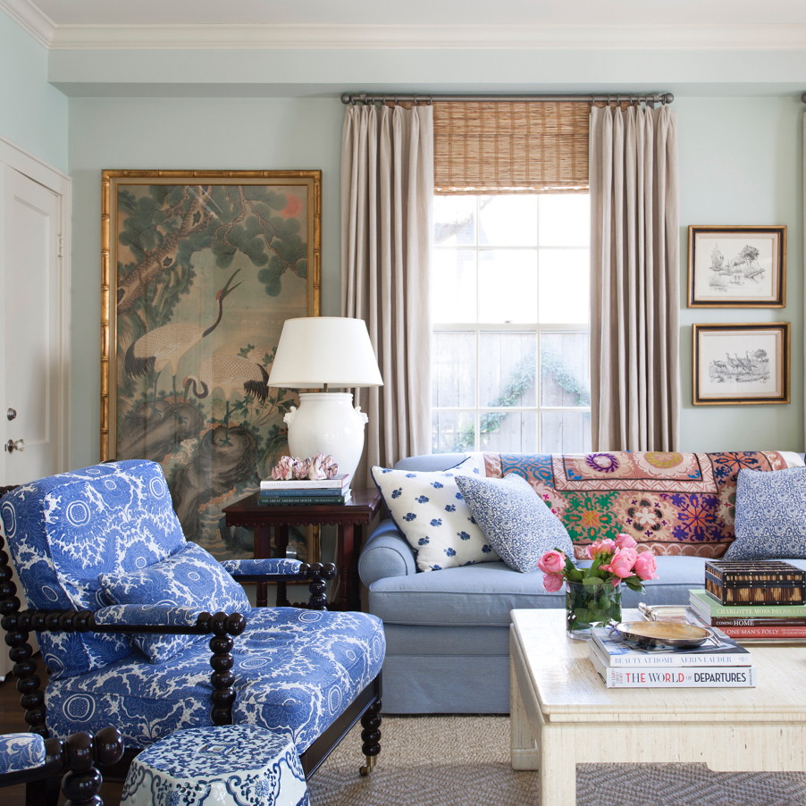 a living room filled with furniture and a painting on the wall