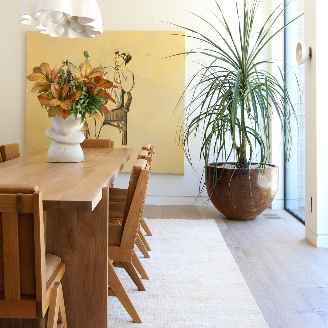 a dining room with a table and chairs and a potted plant