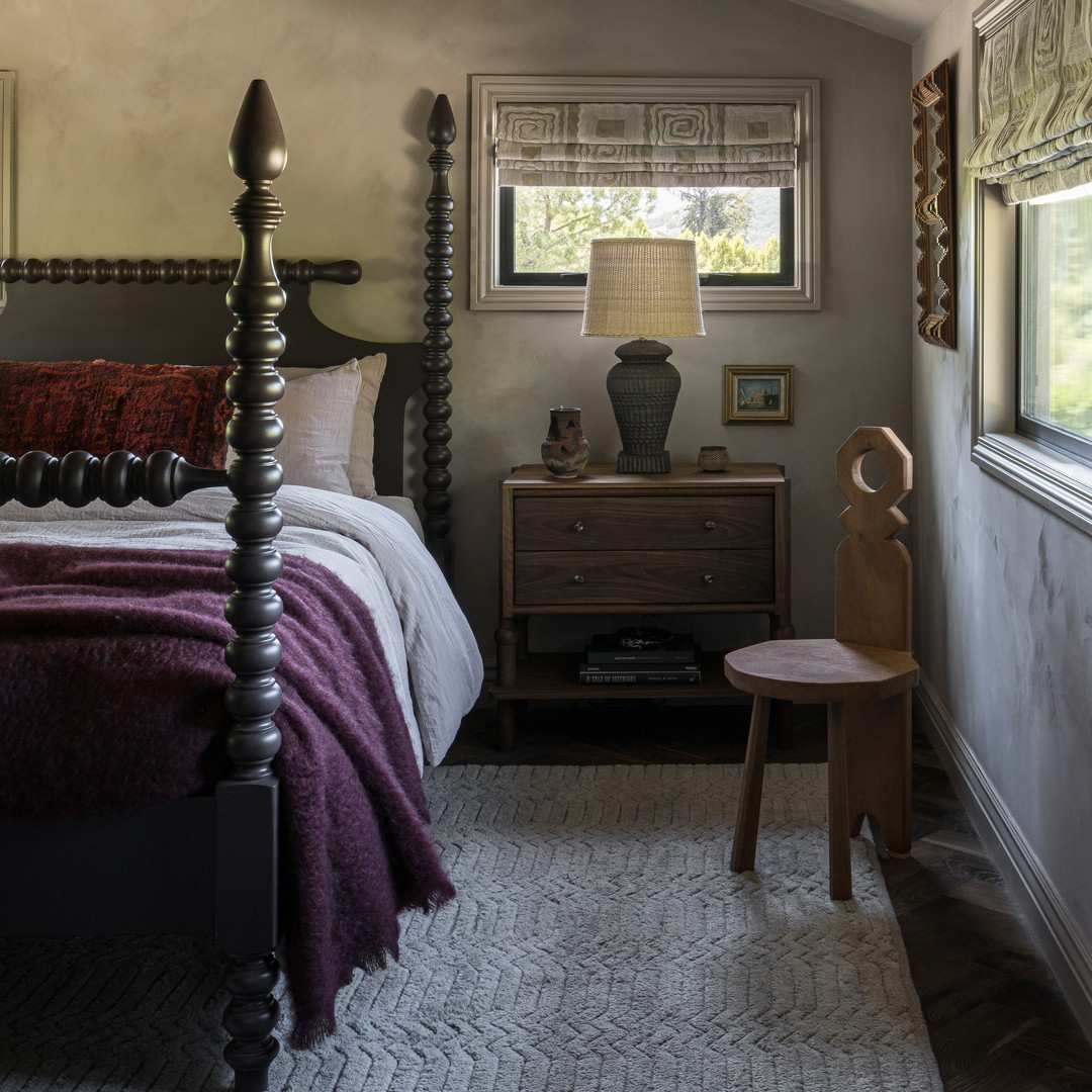 a bed room with a neatly made bed and a chair