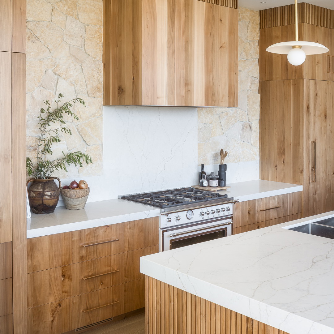 a kitchen with a marble counter top and wooden cabinets