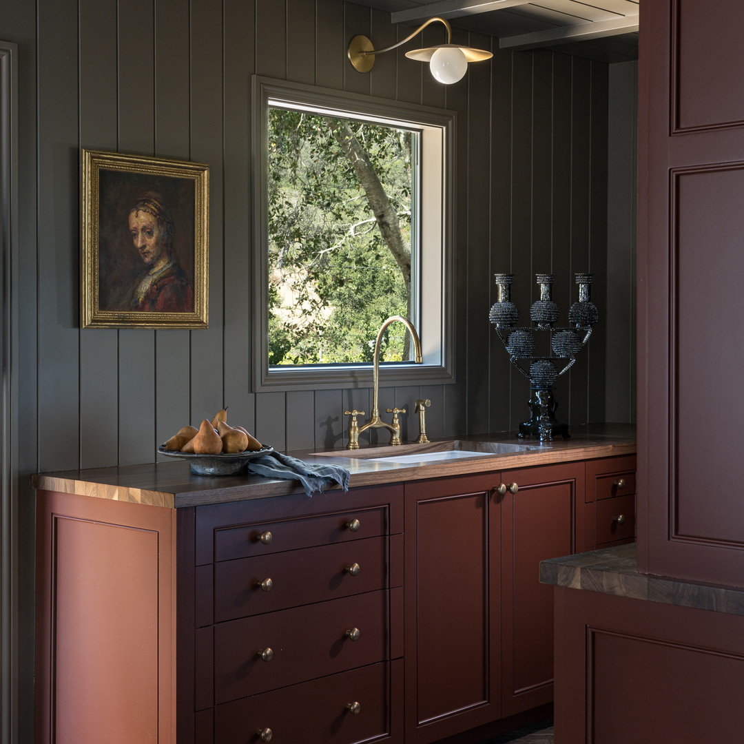 a kitchen with a sink and a painting on the wall