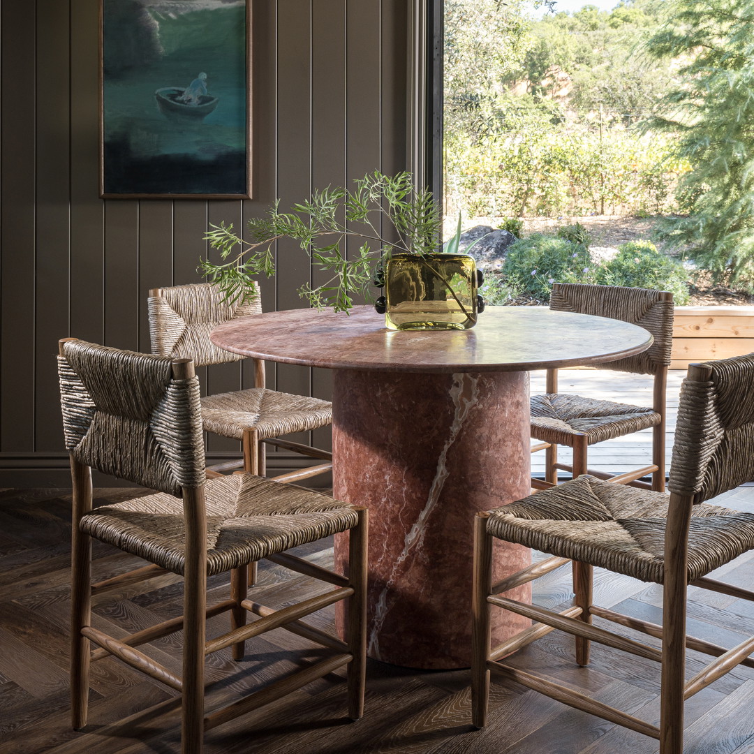 a dining room with a round table surrounded by chairs