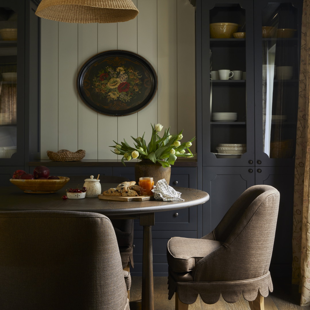 a dining room table with two chairs and a potted plant