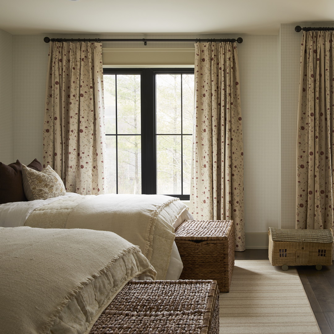 a bedroom with two beds, a table and two windows