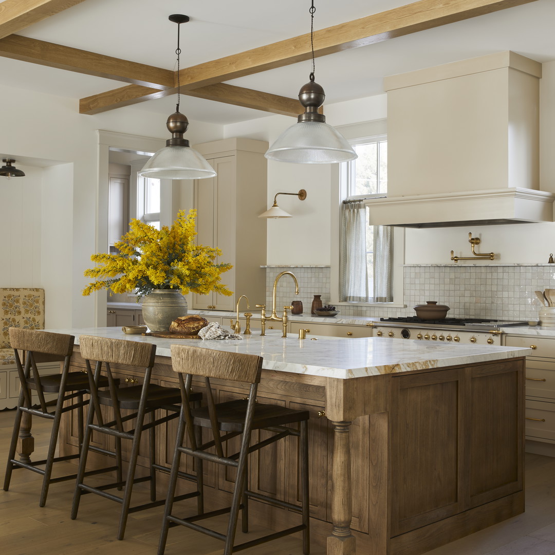 a large kitchen with a center island and wooden chairs