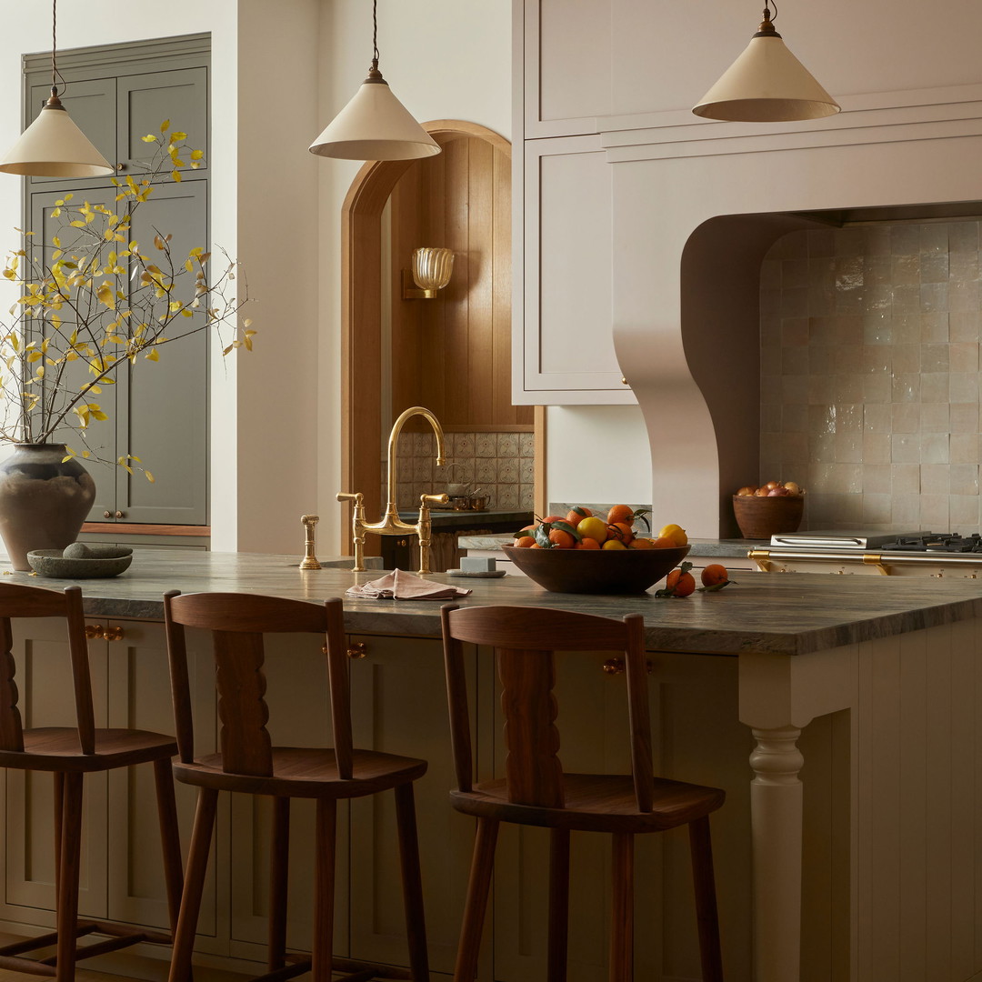 a kitchen with a center island with a bowl of fruit on it