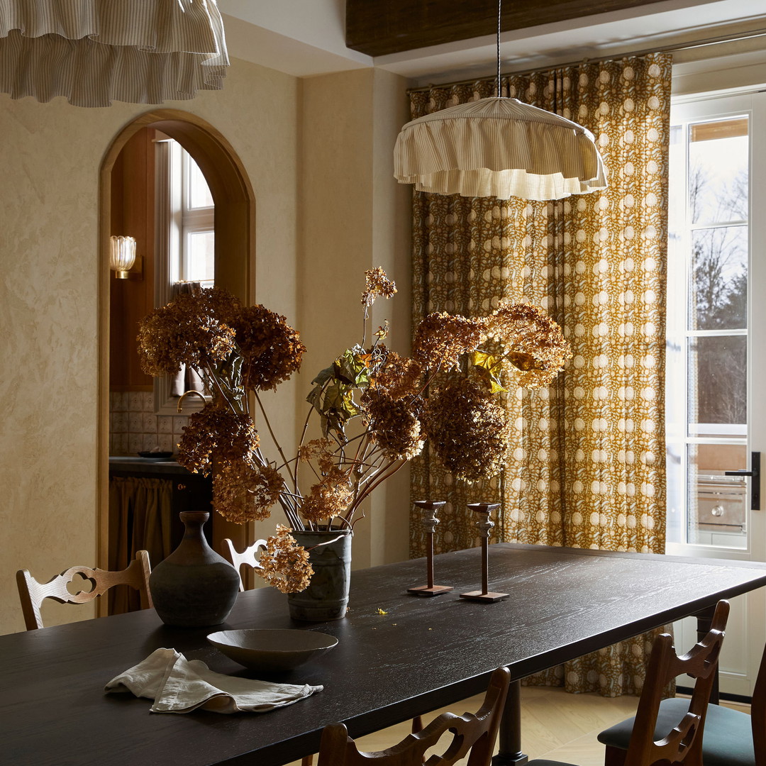 a dining room table with a vase of flowers on it