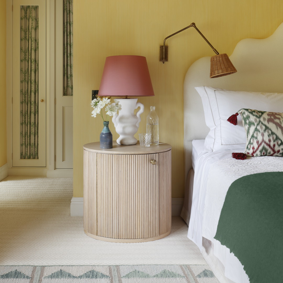 a bedroom with yellow walls and a white bed