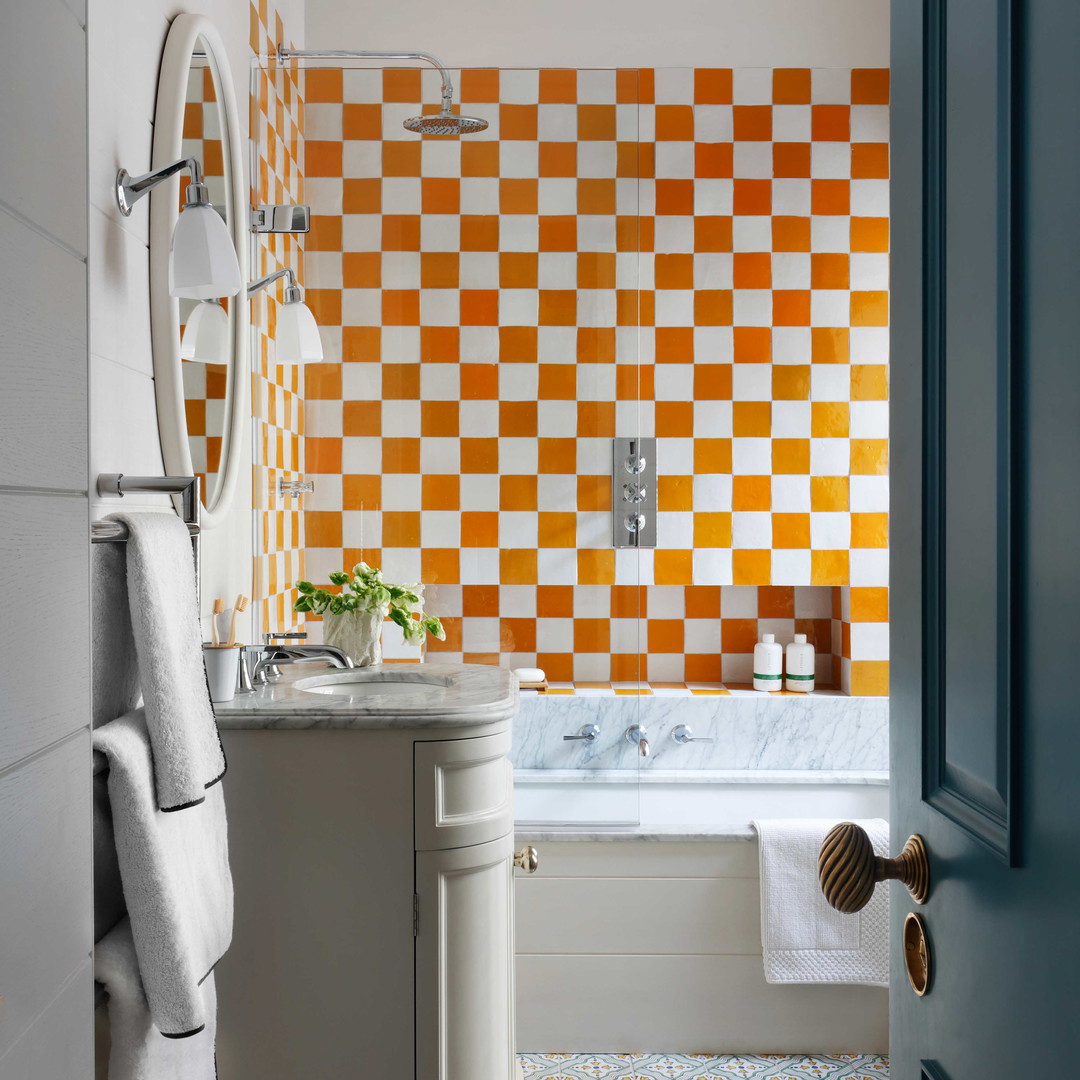 a bathroom with orange and white tiles on the wall