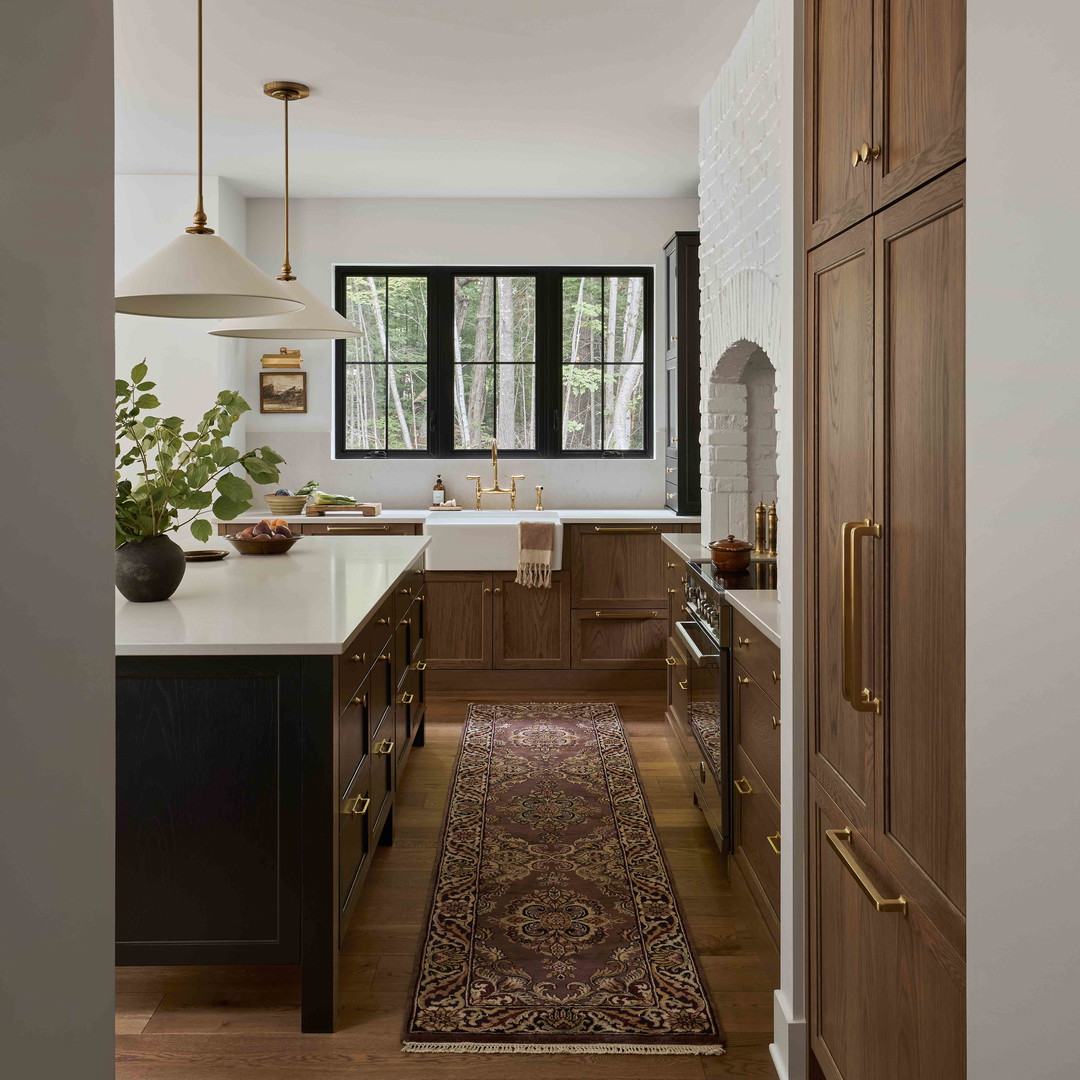 a kitchen with a rug on the floor and wooden cabinets