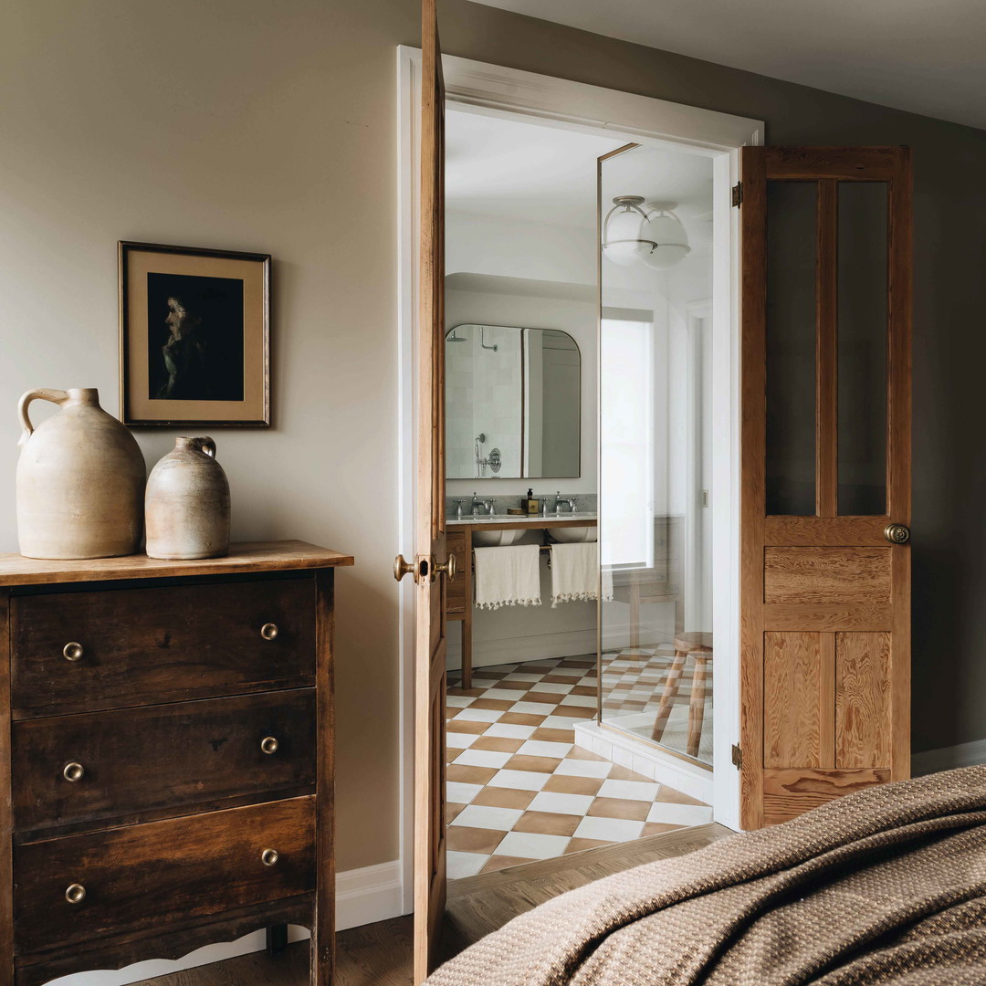 a bedroom with a bed, dresser and mirror