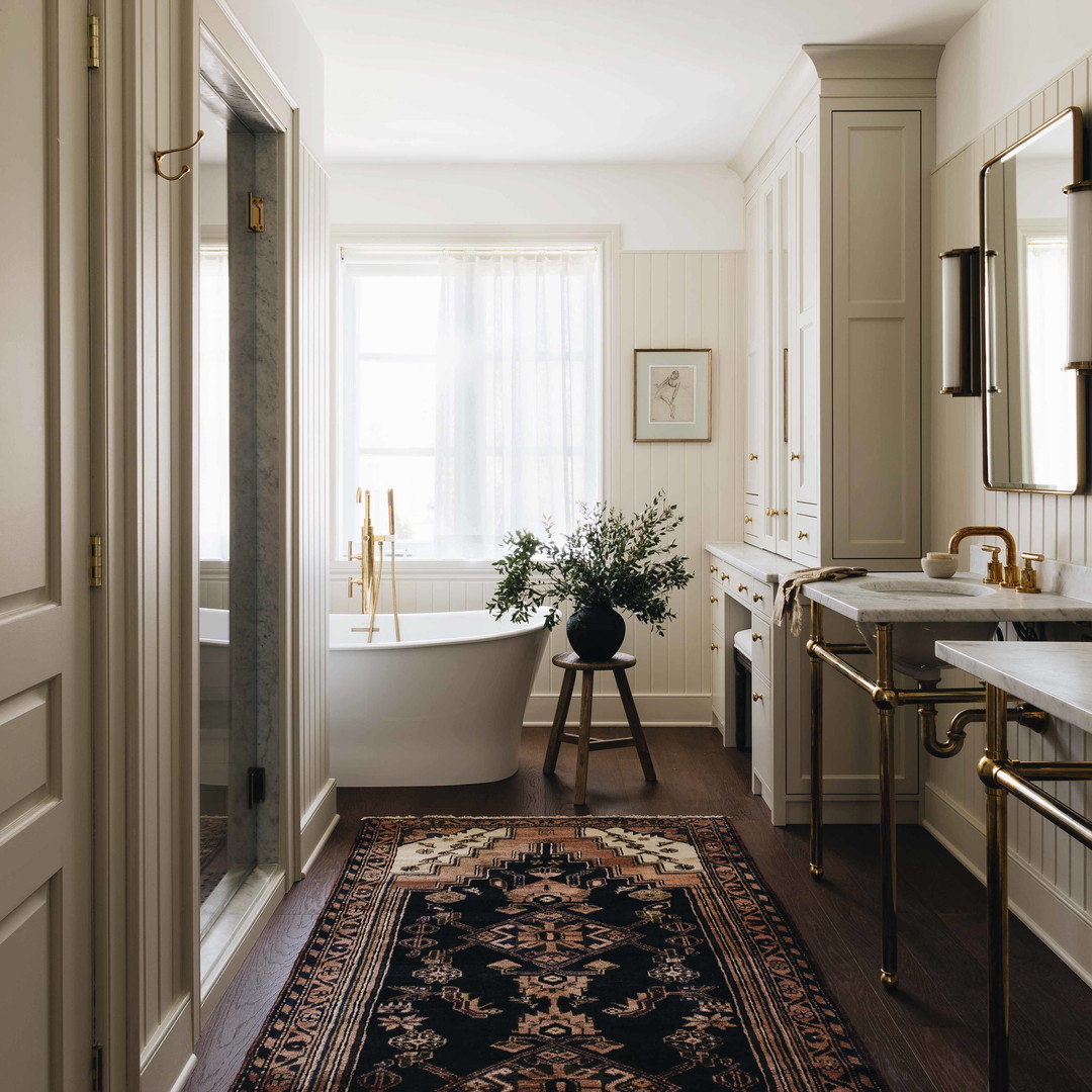 a bath room with a rug a sink and a bath tub