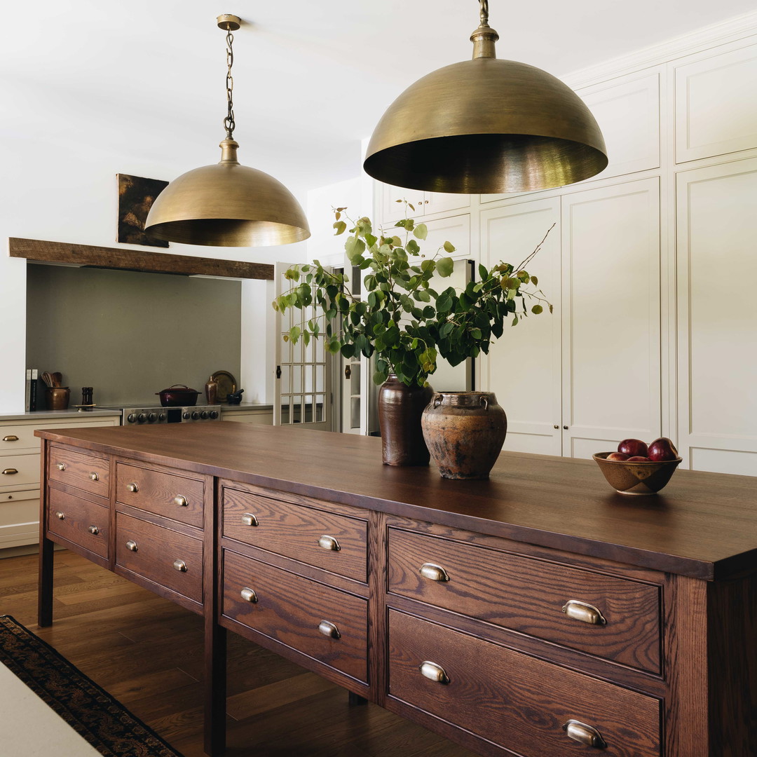 a large wooden table with two lamps hanging over it