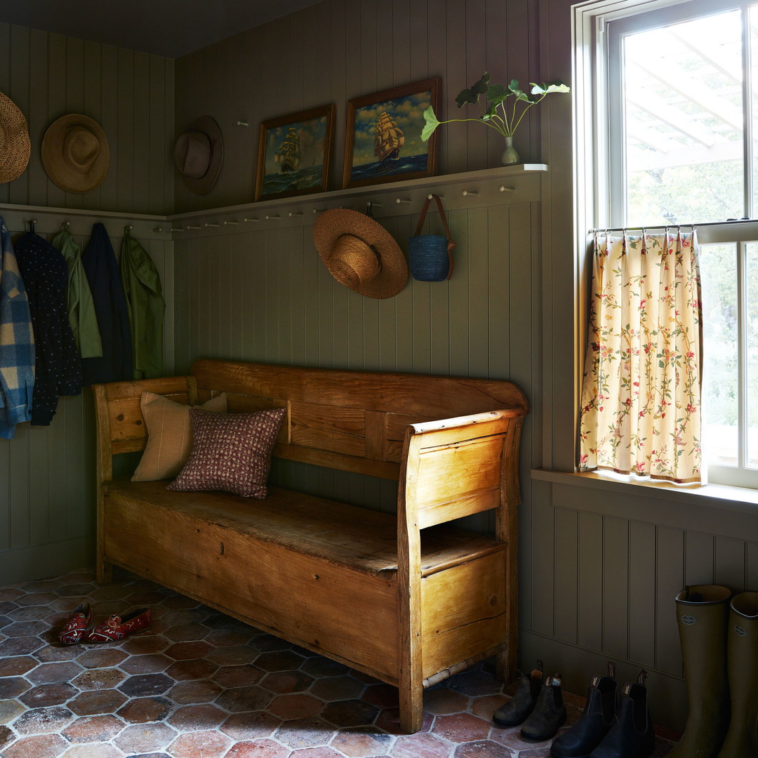 a wooden bench sitting in a room next to a window