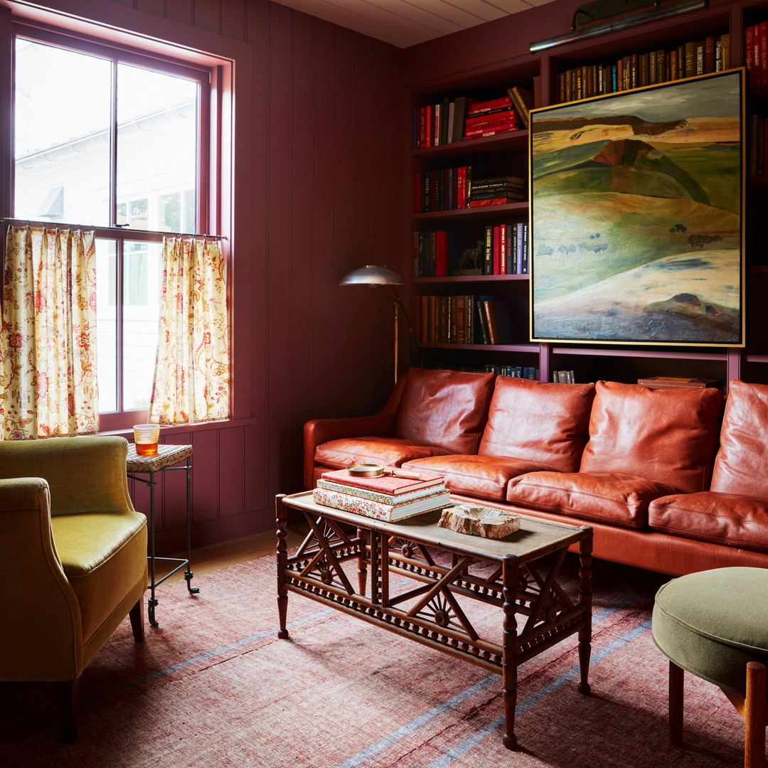 a living room filled with furniture and a painting on the wall