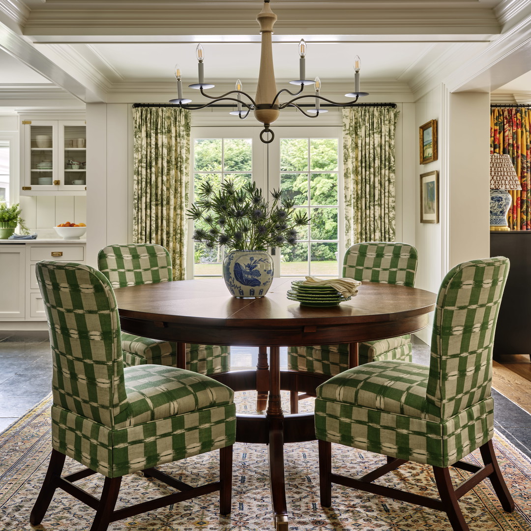 a dining room table with green chairs and a chandelier